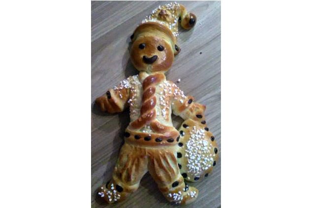 Hefeteigweihnachtsmann mit einem Sack voller Süßigkeiten, mit Hagelzucker und Schokoladentröpfchen dekoriert.